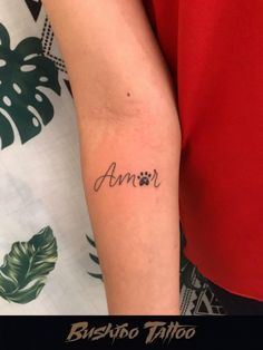 a person with a tattoo on their arm that reads, annr and has an animal paw