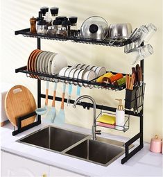 a kitchen sink filled with dishes and utensils next to a wall mounted dish rack