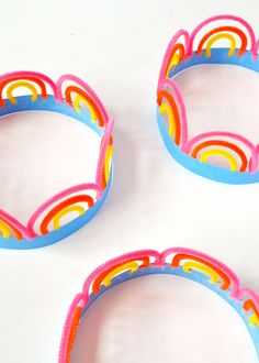 three colorful plastic bowls sitting on top of a white table