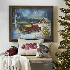 a christmas tree is next to a painting on the wall with an old red truck