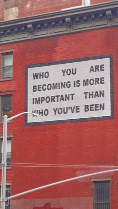 a sign on the side of a building that says, who you are becoming is more important than ho you've been