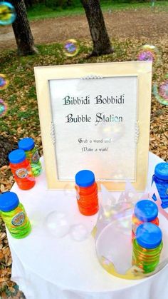 there are many bubbles in the air near a table with a sign on it that says bubble station