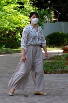 a woman wearing a face mask walking down the street