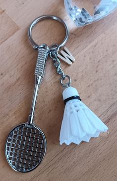 a badminton racket and shuttle keychain sitting on a table