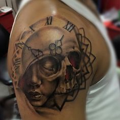 a woman's arm with a clock and skull tattoo on it