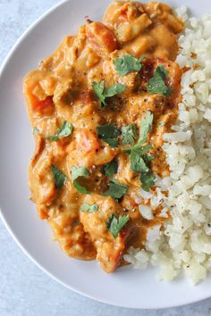 a white plate topped with rice and meat covered in sauce