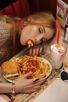 a woman is eating french fries and hotdogs