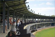 a group of people standing on the side of a baseball field next to bleachers