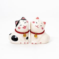 two ceramic cats sitting next to each other