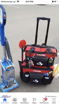 two pieces of luggage sitting next to each other on top of a parking lot near a vacuum