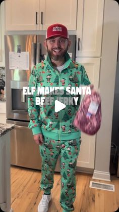 a man in green christmas pajamas holding up a pink object with the words elf magic santa be merry on it