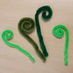 two green hair clips sitting on top of a wooden table