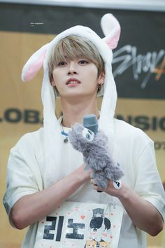 the boy is wearing bunny ears and holding a stuffed animal