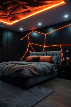 a large bed in a room with orange lights on the ceiling and walls behind it