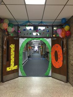 the entrance to an office building decorated with balloons and streamers in the shape of numbers