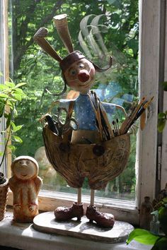 a window sill with a statue of a rabbit on top of it next to a potted plant