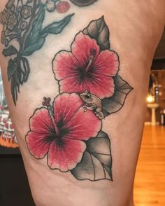 a close up of a tattoo with flowers on the side of a person's leg