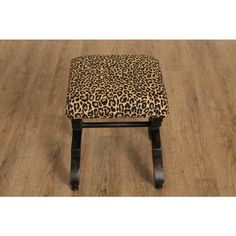 a leopard print footstool sitting on top of a wooden floor