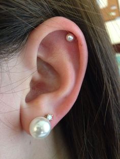 a close up of a person's ear with pearls