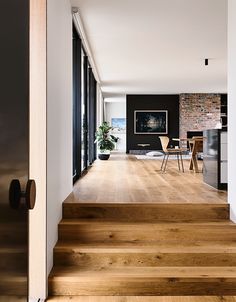 the interior of a modern home with wood flooring