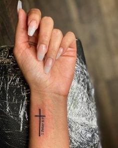 a woman with a cross tattoo on her wrist