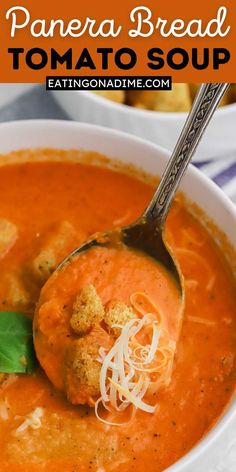 a bowl of tomato soup with bread croutons and parmesan cheese