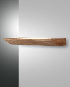 a wooden shelf mounted to the side of a wall next to a white and gray wall