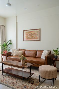 a living room filled with furniture and a large painting on the wall above it's windows