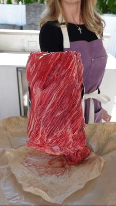 a woman sitting at a table with some food in front of her and an object made out of plastic wrap