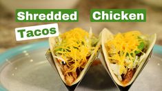 two shredded chicken tacos on a plate with the words shredded chicken and taco's