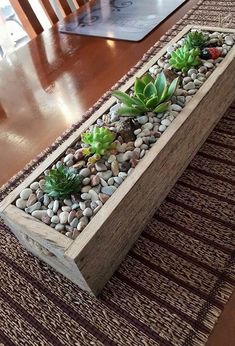 a wooden planter filled with succulents on top of a table