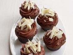 cupcakes with chocolate frosting and white sprinkles on a plate