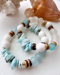 Great bracelet for all seasons! Add something fresh and new to your accessory collection that can be stacked, worn alone or mixed together with your favorite pieces. These uniquely ornate beachy inspired neutral IzaTazi bracelets will definitely make your look stand out! this bracelet features:  1 Size 7" stretch style bracelet    Organic shaped Larimar chips  Blue and white African recycled sea glass beads  14K Gold filled accents  Coconut shell beads  BRACELET CARE INSTRUCTIONS: *Keep jewelry Bohemian Beaded Bracelets With Natural Stones For Beach, Turquoise Hand Wrapped Wrap Bracelet For Beach, White Stackable Beaded Bracelets For Beach, Ocean-inspired Beaded Bracelets For Beach, Blue Hand-strung Bracelets For Vacation, Blue Stackable Jewelry For The Beach, Bohemian Hand-strung Bracelets For Vacation, Vacation Blue Hand-strung Bracelets, Blue Stackable Friendship Bracelets For Beach