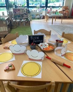 the table is set up with paper plates and pizzas on them for children to eat