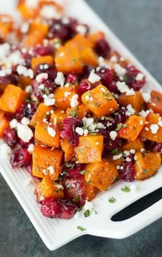 two serving trays filled with sweet potatoes and cranberry sauce, topped with feta cheese