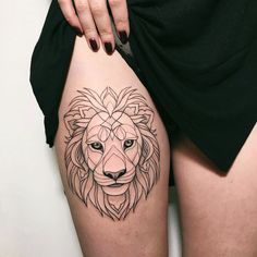 a woman's thigh with a lion tattoo on it