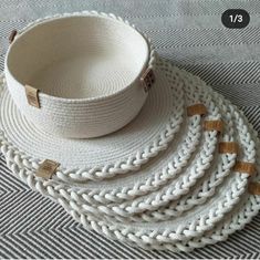 three white baskets sitting on top of a rug next to each other with wooden handles