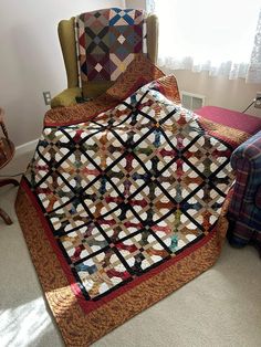 a quilted blanket on top of a chair next to a window