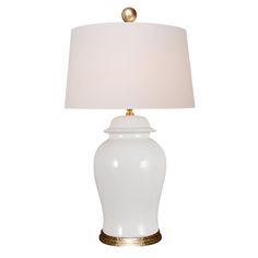 a white lamp with a gold base and a white shade on the top of it