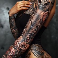 a woman with an owl tattoo on her arm holding a feather and flower arrangement in front of her body