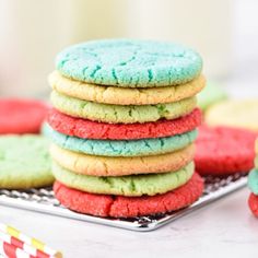 a stack of colorful cookies sitting on top of a metal tray next to strawberries