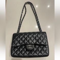 This Chanel Shoulder Bag Is A Timeless Classic, Crafted From Black Quilted Lambskin Leather With Silver Hardware Accents. The Authentic Bag Id# 19277509 The Bag Features A Rectangular Shape With A Turn Lock Closure And Double Handles For Easy Carrying. It Has A Large Size With A Depth Of 3.75 Inches, A Width Of 12 Inches, And A Height Of 8 Inches. The Bag Has Four Inside Pockets And One Outside Pocket, Providing Ample Space For Your Essentials. It Also Comes With A Chain Strap That Can Be Adjusted To A Drop Of 12.75 To 23.5 Inches. The Bag Is Adorned With Silver Stitching Accents And Chanel's Signature Burgundy Leather Lining. This Classic Double Flap Shoulder Bag Is A Must-Have For High-end Travel Shoulder Bag With Cc Turnlock Closure, Luxury Office Bag With Double Flap, Luxury Double Flap Shoulder Bag For Formal Occasions, Luxury Business Shoulder Bag With Double Flap, Luxury Double Flap Business Bags, Everyday Clutch Bag With Cc Turnlock Closure, Clutch Bags With Cc Turnlock Closure For Everyday, Luxury Double Flap Shoulder Bag For Business, Cc Turnlock Clutch Bag