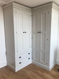 an empty room with white cupboards and wood flooring in the middle of it