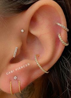 an ear with three different types of piercings on it's sides and the words gabi piercer written below them