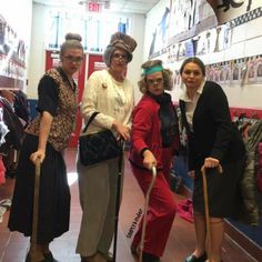 four women are posing for the camera with their canes and hats on in a store