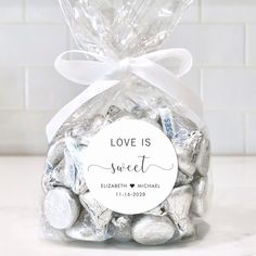 a bag filled with white chocolate candies on top of a marble counter next to a brick wall