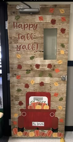 a red truck painted on the side of a wooden door with fall leaves and pumpkins