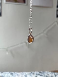 Handmade sterling silver Sea Glass necklace, made with recycled silver, and genuine Sea Glass from the Jurassic Coast. This necklace has one Small piece of Light Brown Sea Glass, and is very dainty and elegant.  This necklace is a perfect gift for a special occasion, and is perfect for Sea Glass lovers! The chain is 18" (45cm), and has an easy closure. All of the silver on the necklace is 925 Sterling Silver, including the chain and small jump rings! Feel free to message me for any additional information, or for commissions/custom requests! Untreated Teardrop Pendant Necklace As A Gift, Untreated Teardrop Pendant Necklace For Gifts, Minimalist Brown Sterling Silver Jewelry, Sterling Silver Brown Round Pendant Necklace, Untreated Sterling Silver Necklaces As Gifts, Sterling Silver Brown Necklace For Gift, Brown Sterling Silver Round Pendant Necklace, Untreated Silver Necklace As A Gift, Brown Sterling Silver Teardrop Necklace