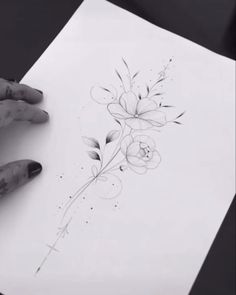 someone is drawing flowers on paper with their hands