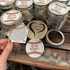 a person holding a jar with some personalized items in it on top of a wooden table